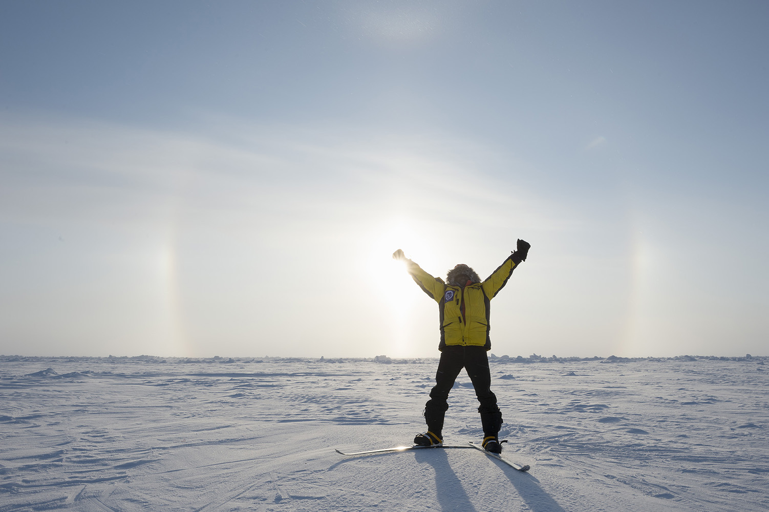 Renny reaching the North Pole, with a sun halo in the background
